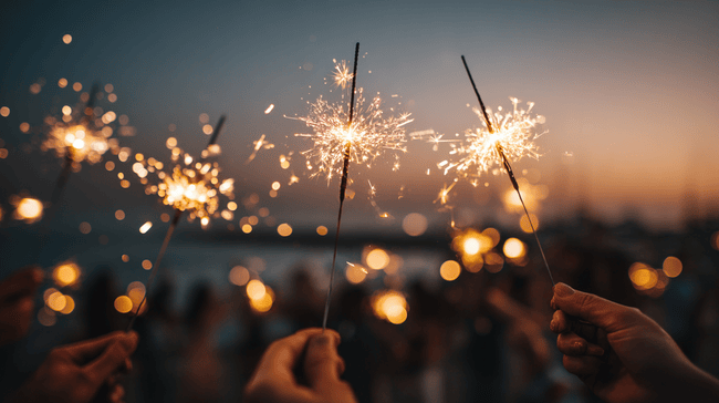 Funeral Homes in Berkley, MI, for celebrations of life supportive group embracing indoors and people holding sparklers at dusk.