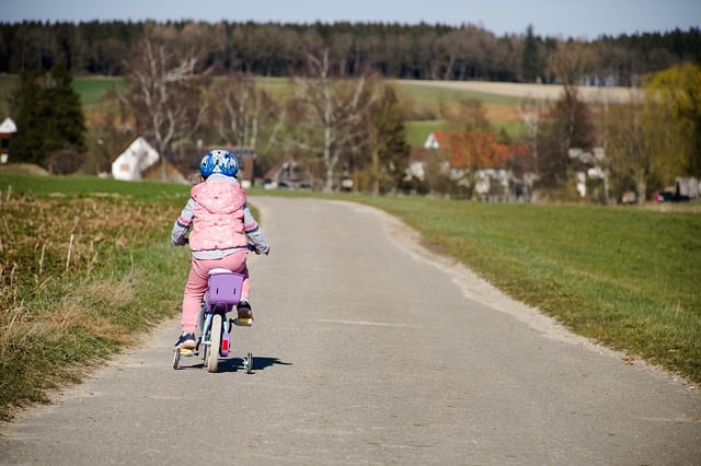 Child riding bicycle along a quiet road reflecting compassionate funeral care in Royal Oak, MI